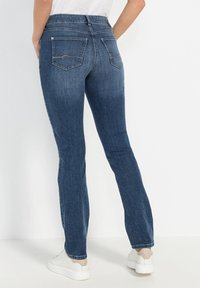 Jeans de mezclilla azul oscuro con un diseño de pierna recta y una cinturilla de altura media. Presentan dos bolsillos traseros con detalles de costura y un acabado limpio.