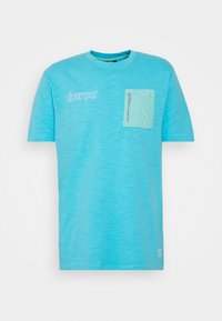 T-shirt turquoise à col rond, manches courtes, avec une poche poitrine avant munie d'une fermeture éclair. Logo "barça" imprimé en blanc.