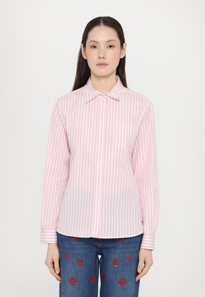 Pink and white striped button-up shirt with a collar and a pocket, made of lightweight fabric, paired with embroidered denim jeans.
