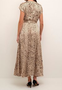 Maxi šaty s leopardím vzorem z lehkého materiálu, mají krátké rukávy a stažený pas. Lem sahá až k ankám.