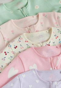 Cinq bodies pour bébé pliés dans des couleurs pastel avec des motifs floraux, cerises et cœurs, disposés en pile.