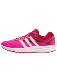 Scarpa da ginnastica rosa con tomaia testurizzata, tre strisce bianche, collo imbottito e suola in gomma. Leggera e progettata per il comfort.