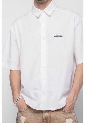 Weißes kurzärmliges Hemd mit Knopfleiste, klassischem Kragen und in Marineblau gesticktem Schriftzug 'KAOTIKO'. Hergestellt aus glattem, geschmeidigem Stoff.