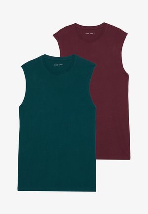 Dve brezrokavne majice, ena v teal barvi in ena v burgundski, izdelane iz mehkega materiala. Imajo okroglo izrez in čist, moden kroj.