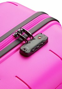 Pink hard-shell suitcase with a textured surface, black zipper, and combination lock. Features sleek design and durable construction.