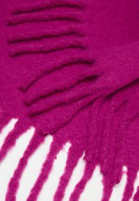 Bufanda de lana color fucsia con una textura suave, bordes con flecos y un acabado liso, destacando su color vibrante y apariencia acogedora.