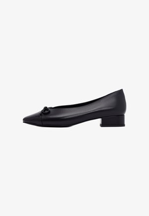 Ballerine in pelle nera con punta affusolata, design minimalista e un piccolo tacco quadrato. Presentano un sottile dettaglio ad anello sulla parte anteriore.