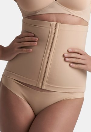 Gaine beige avec une texture lisse, dotée de plusieurs fermetures à crochets et œillets sur le devant et d'une coupe mi-haute.