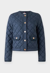 Marineblå quilted jakke med rund halsutringning, gullfargede knapper og to lommepakker. Har et teksturert stoff og kort passform.