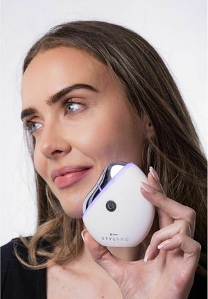 StylPro device features a white body with a glossy silver top, purple accent ring, and a power button. It has a curved, ergonomic shape.