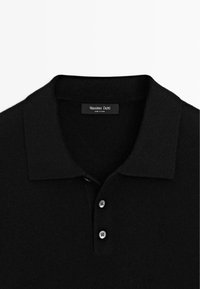 Czarna dzianinowa koszulka polo o miękkiej fakturze, z kołnierzykiem, trzema guzikami oraz metką marki Massimo Dutti umieszczoną wewnątrz kołnierza.
