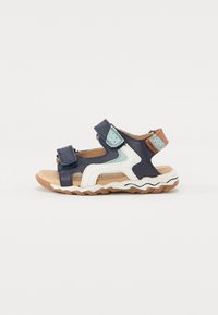 Navy blue sandal with Velcro straps, textured synthetic upper, white and light blue accents, and a beige rubber sole with zigzag pattern.
