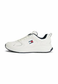 Baskets blanches de sport avec une tige en cuir texturé, accents bleu marine, écusson logo sur le côté et semelle rembourrée pour le confort.