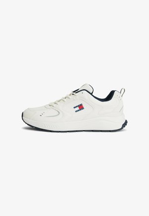Weiße Sportschuhe mit einem strukturierten Lederoberteil, marineblauen Akzenten, einem Logo-Patch an der Seite und einer gepolsterten Sohle für Komfort.
