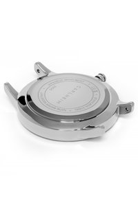 Caja de reloj de acero inoxidable con un acabado cromado brillante, que presenta asas y una parte posterior grabada con detalles del movimiento.