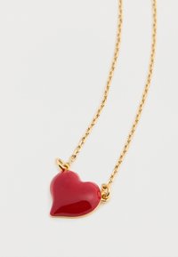 Zlatý náhrdelník s lesklým príveskom v tvare červeného srdca. Prívesok má hladkú textúru a je pripojený pomocou malých zlatých očiek.