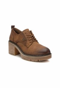 Zapato de cuero marrón hasta el tobillo con punta redonda, diseño de cordones, tacón grueso y suela de goma texturizada. Presenta costuras y un logo lateral.