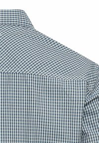 Niebiesko-biała koszula w kratę z sztywnym kołnierzem. Posiada małe kwadratowe wzory i gładką bawełnianą teksturę. Starannie wykonane szwy.