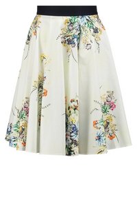 Jupe à imprimé floral en crème, avec une ceinture noire, de forme A, et des plis, mettant en avant des motifs colorés de fleurs sauvages.