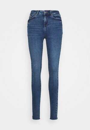 Jeans skinny em denim azul escuro, com uma cintura alta, design clássico de cinco bolsos e desbotamento subtil nas coxas e joelhos.