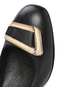 Scarpa in pelle nera con punta arrotondata, dotata di una larga cinturino nero e un accento geometrico di fibbia dorata. Superficie testurizzata e interno liscio.