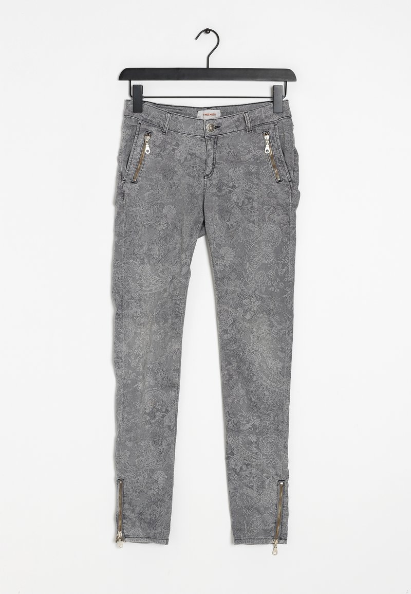 Jeans ajustados de estampado floral gris con bolsillos con cremallera y cremalleras en los tobillos, hechos de una tela texturizada. Colgados de un gancho.
