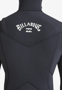 Czarny piankowy strój z gładką fakturą, z białym logo "Billabong" z tyłu oraz kontrastowymi przeszyciami.