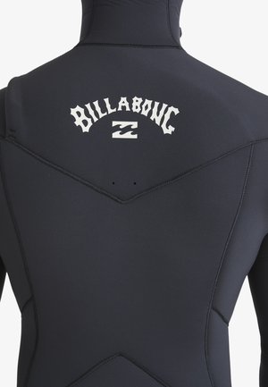 Une combinaison de plongée noire au toucher lisse, avec un logo blanc "Billabong" dans le dos et des coutures contrastées.