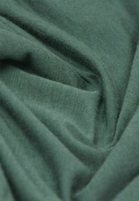Tissu vert au toucher lisse, présentant un motif de tissage subtil. Le matériau semble léger et flexible, avec un drapé doux.