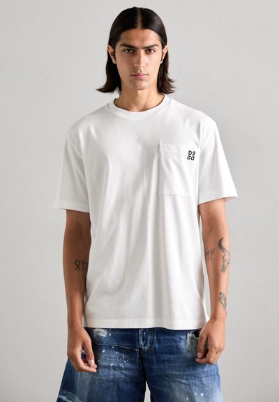 T-shirt bianca in cotone con scollo rotondo e maniche corte. Presenta una tasca sul petto sinistro con logo stampato. Design liscio e minimalista.