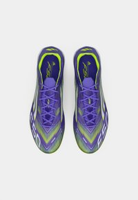 Pair of purple and neon green athletic shoes with laces, viewed from above on a white background.