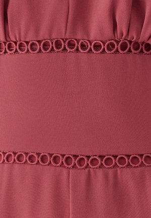 Artimos planas rausvos tekstūruotos audinio su dviem horizontaliais dekoratyviniais juosteliais, siuvinėtais apskritų kilpų raštais.