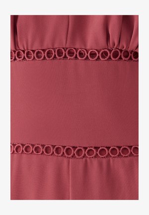 Artimos planas rausvos tekstūruotos audinio su dviem horizontaliais dekoratyviniais juosteliais, siuvinėtais apskritų kilpų raštais.