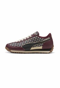 Sneaker atletico bordeaux e nero con un motivo houndstooth testurizzato, lacci bianchi e una suola in gomma naturale con piccole protuberanze.