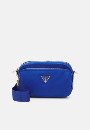 Kompakte blaue Umhängetasche mit zwei Reißverschlussfächern und einem silbernen Guess-Logo auf der Vorderseite, mit verstellbarem Trageriemen.