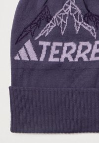 Berretto lavorato a maglia viola con risvolto a coste, caratterizzato da un design di montagne bianche e il logo "TERREX" in viola chiaro. Morbido al tatto e con elasticità.