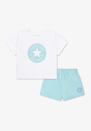 Camiseta blanca de manga corta con el logo azul de Converse All Star combinada con pantalones cortos de cintura elástica en azul claro con un pequeño emblema de estrella.