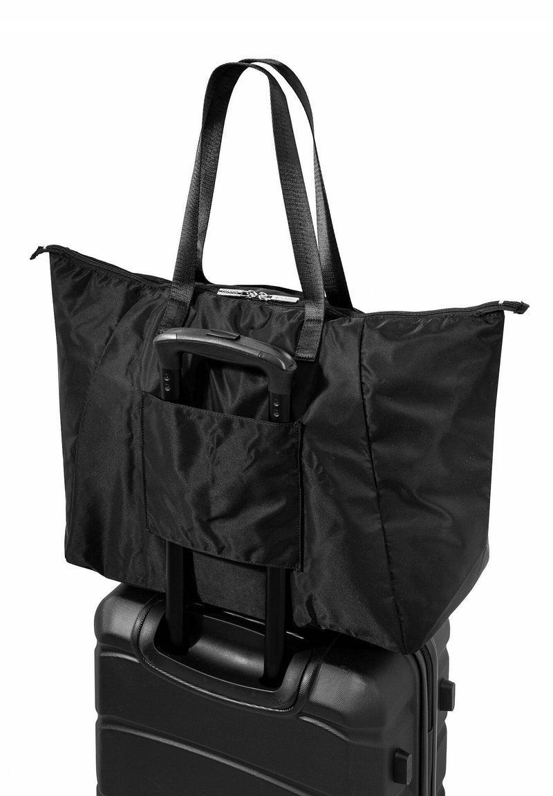 Zwarte reistas gemaakt van nylon, met dubbele handvatten, ritssluiting en een voorkantvak voor een kofferhandvat. Textuur oppervlak.