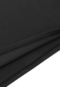 Czarna tkanina o gładkiej fakturze, z zagiętymi krawędziami i widocznymi szwami. Materiał wydaje się elastyczny i lekki.