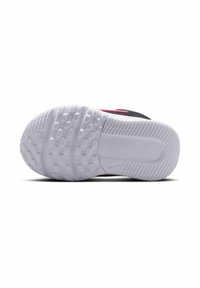 Suela de zapato atlético negro que presenta una parte inferior de goma blanca texturizada con patrones hexagonales y un logotipo de Nike en el centro. Acentuado con elementos en color rosa.