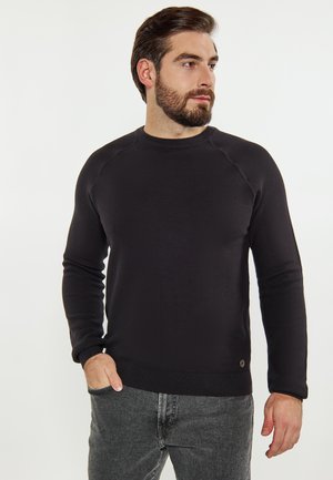 Schwarzer gestrickter Pullover mit rundem Halsausschnitt und langen Ärmeln. Mit gerippten Bündchen und Saum, strukturiertem Stoff und dezentem Branding am unteren Ende.