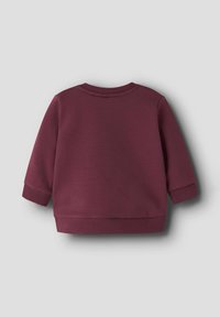 Felpa bordeaux con collo rotondo, maniche lunghe e polsini a costine. Realizzata in tessuto morbido, con un design semplice e una lunghezza cropped.