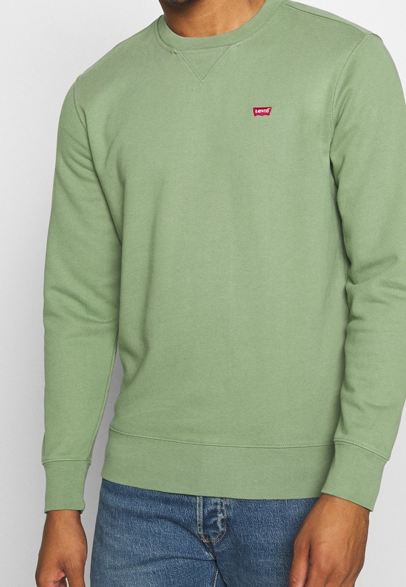 Sudadera verde con cuello redondo, puños y dobladillo acanalados. Presenta un pequeño logo rojo de Levi's en el pecho. Tejido suave y texturizado.