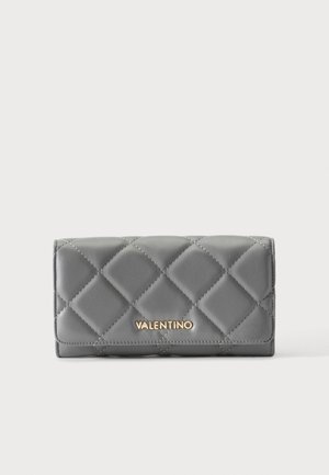 Γκρι καπιτονέ πορτοφόλι με χρυσό λογότυπο Valentino στο κέντρο μπροστά, παρουσιάζεται σε λευκό φόντο.