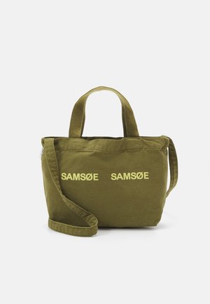 Oliivinvihreä kangaskassi, jossa on kaksi lyhyttä kahvaa, yksi pitkä hihna ja keltaiset "SAMSØE SAMSØE" -tekstit etupuolella.