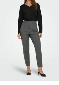 Gray high-waisted pants with a tailored fit, textured fabric, and side stripes; paired with a black long-sleeve V-neck top and black heels.
