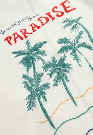 Broderat tyg med palmer i grönt, med texten "Hälsningar från PARADIS" i rött. Krämfärgad bakgrund med färgglada stygn. 