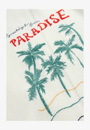 Broderad tyg med palmer i grönt, med texten "Hälsningar från PARADIS" i rött. Ljus bakgrund med färgglada broderidetaljer.