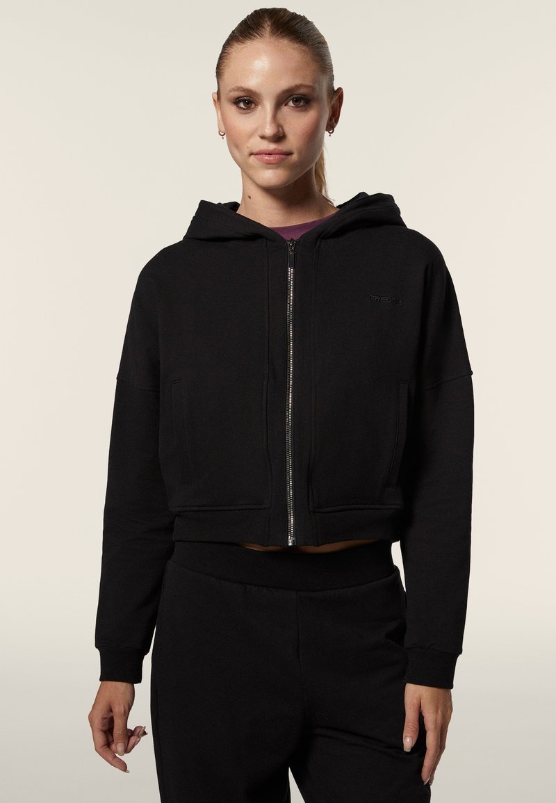 Felpa cropped nera realizzata in morbido misto cotone, con zip completa, cappuccio regolabile e tasche laterali. Design semplice senza fantasie.