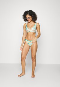 Biquíni de dois peças com um padrão tie-dye em tons de azul e bege, tecido suave e um design de decote em V profundo.